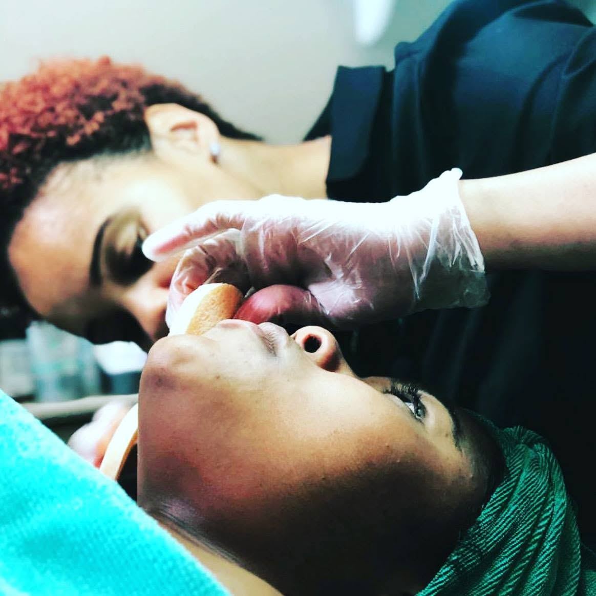 An esthetician performing a facial treatment at SkinBarVII